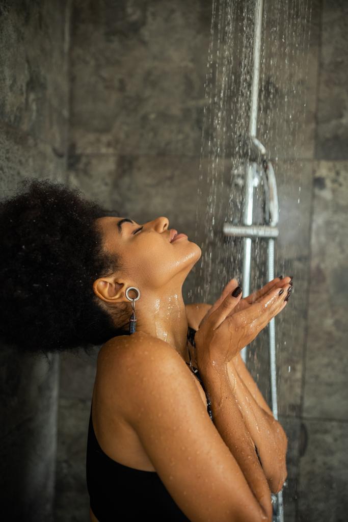 自宅でシャワーを浴びているアフリカ系アメリカ人女性を - 写真・画像