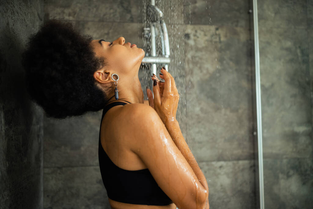 Side view fiatal afro-amerikai nő termés top vesz zuhany otthon  - Fotó, kép