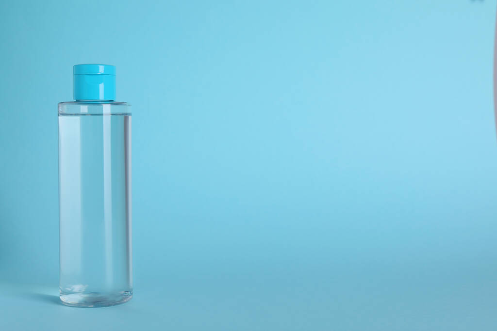 薄い青の背景にマイクロセラー水のボトル。テキストのスペース - 写真・画像