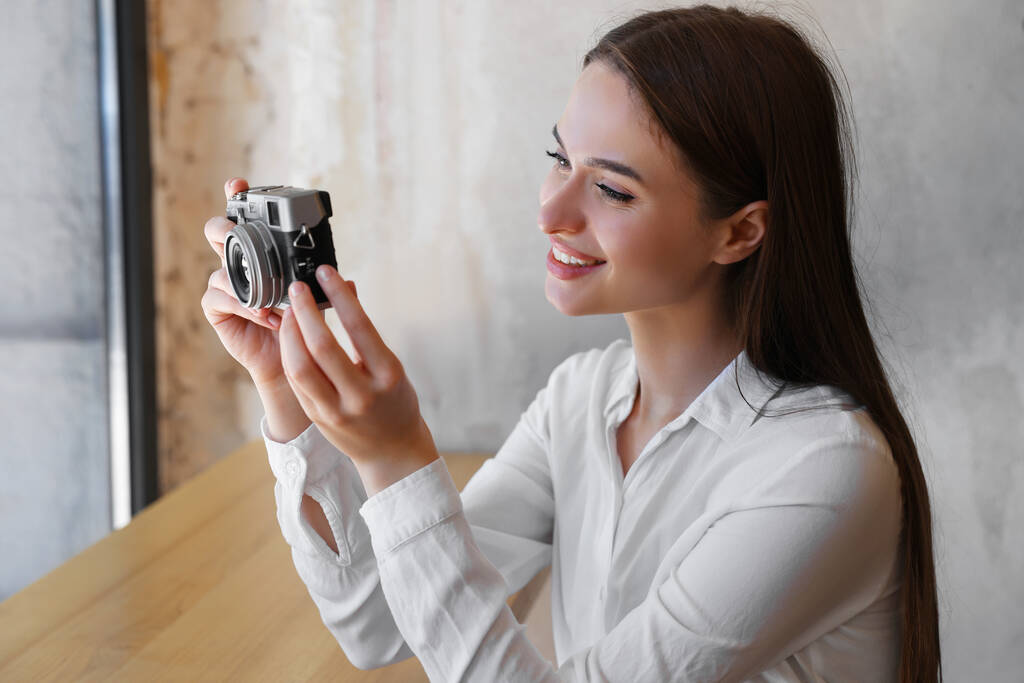 Een jonge vrouw die een foto neemt in het café. Creatieve hobby - Foto, afbeelding