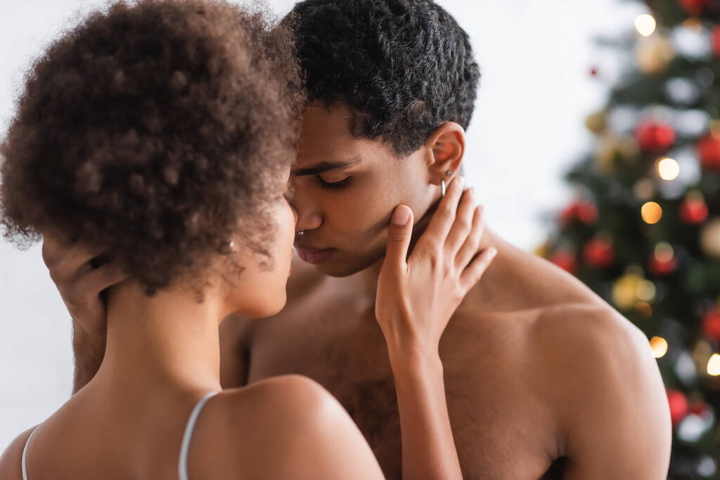 Молоде і сексуальне афро-американське подружжя торкається одне одного, стоячи обличчям до дому. - Фото, зображення