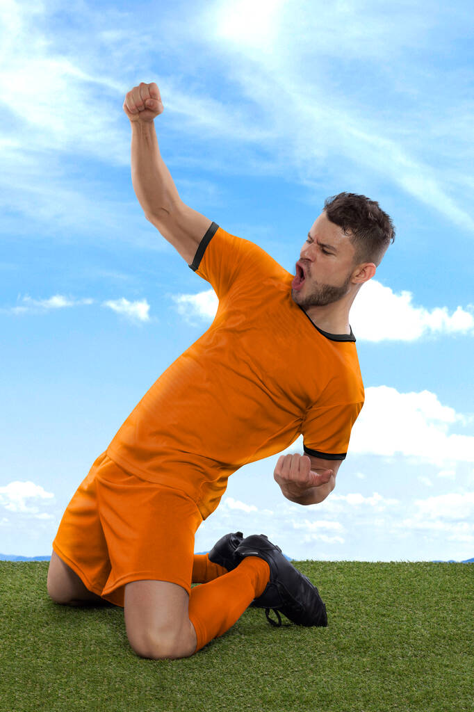 Професійний футболіст з помаранчевою збірною Нідерландів джерсі з хвилюванням кричить, що закидає гол з виразом виклику і щастя на польовій траві і хмарному тлі. - Фото, зображення