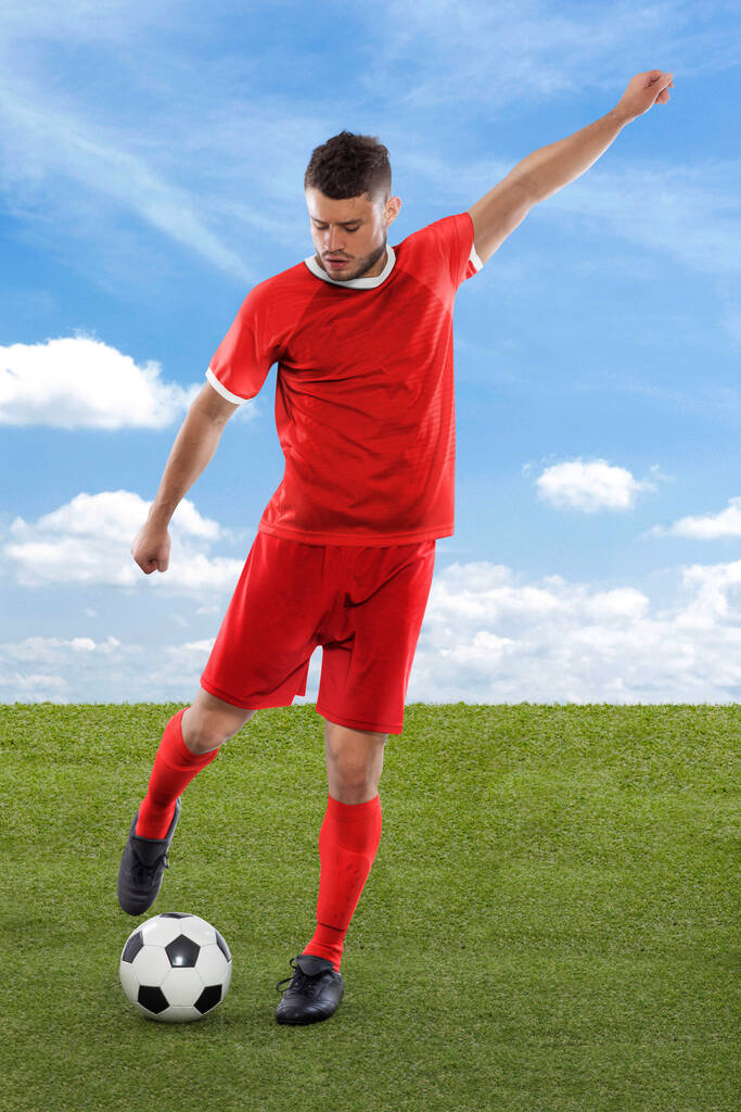 Profesionální fotbalista s tuniským národním týmem dres o skóre gól s výrazem výzvy a rozhodnutí na jeho tváři na poli trávy a cloudu pozadí - Fotografie, Obrázek