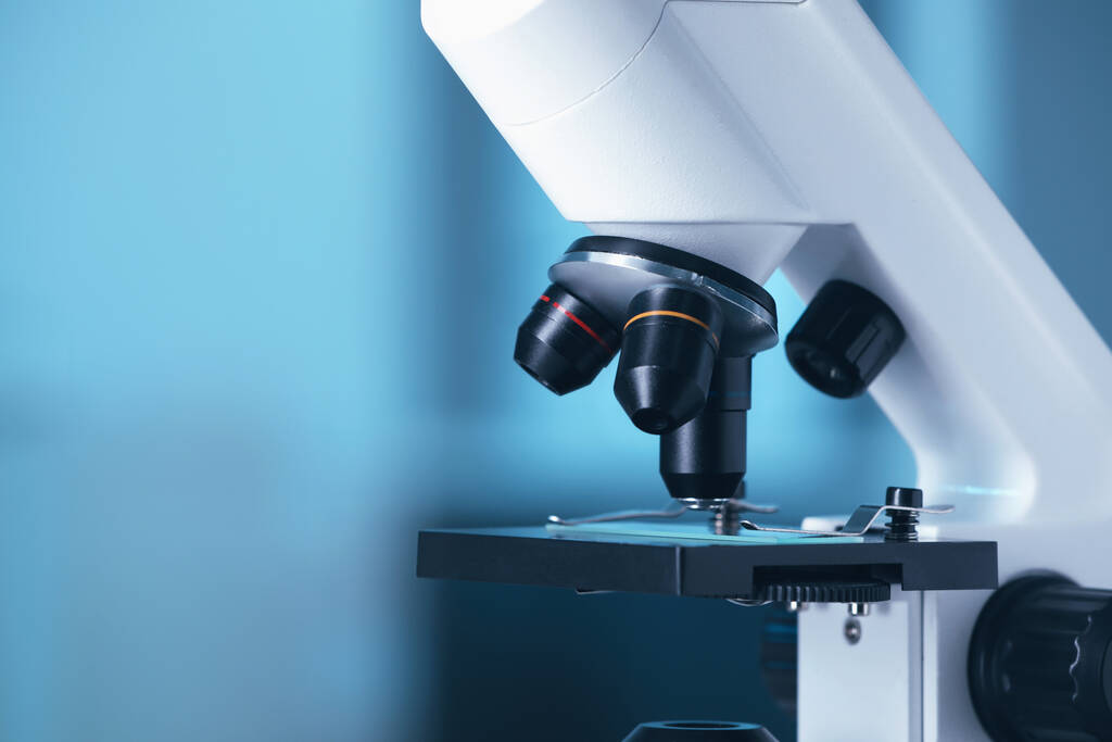 Современный медицинский микроскоп на размытом фоне, крупным планом. Пространство для текста - Фото, изображение