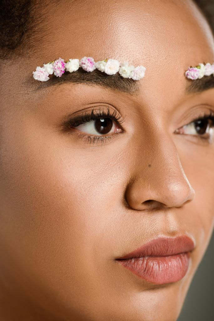 крупним планом красива афроамериканка з квітами на бровах
 - Фото, зображення