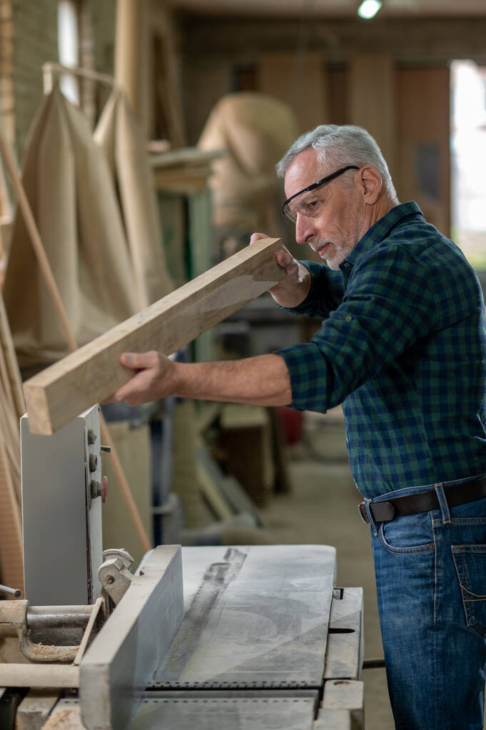 Carpintería. Carpintero trabajando con madera en un taller - Foto, Imagen
