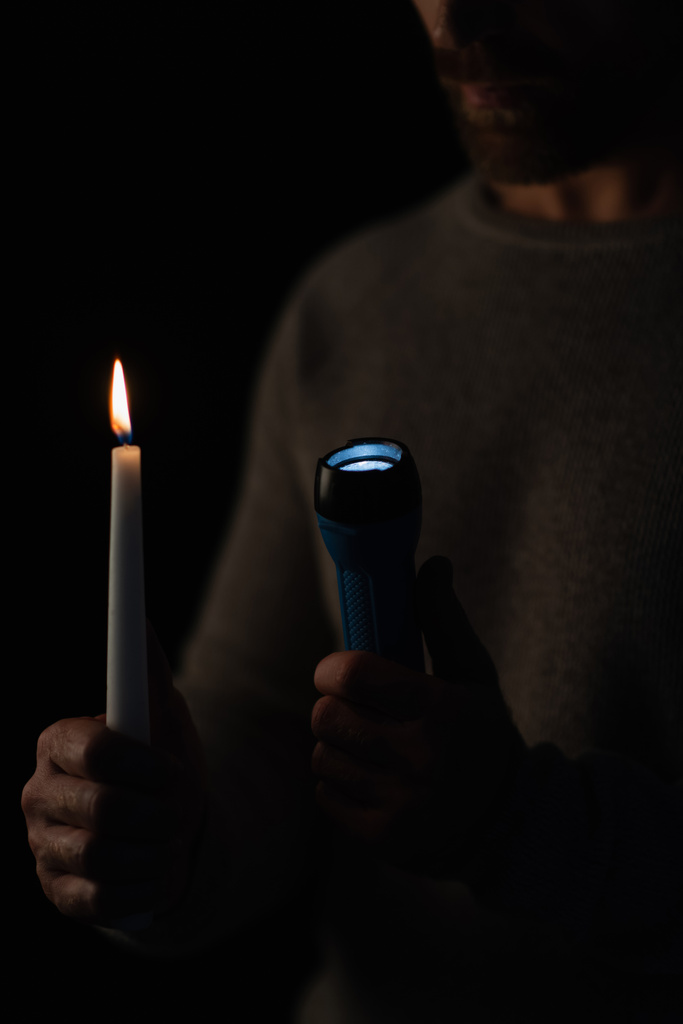 przycięty widok człowieka z latarką i płonącą świecą izolowane na czarno - Zdjęcie, obraz