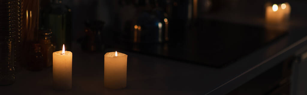 velas ardiendo en encimera de la cocina en la oscuridad durante el apagón de energía, bandera - Foto, Imagen