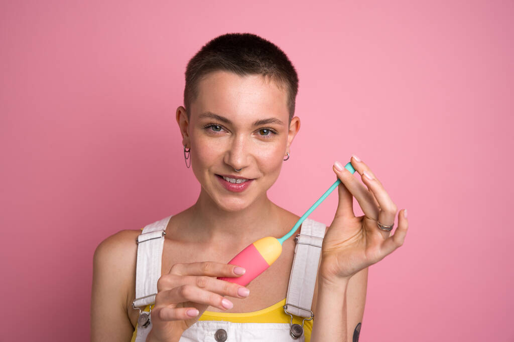 Чудова жінка позує на камеру з іграшкою для дорослих на студії ізольований рожевий фон. концепція мастурбації
 - Фото, зображення