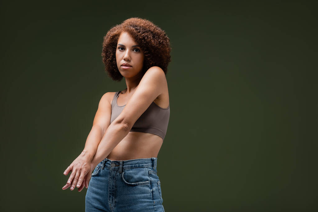 African american woman in top posing isolated on dark green  - Photo, Image