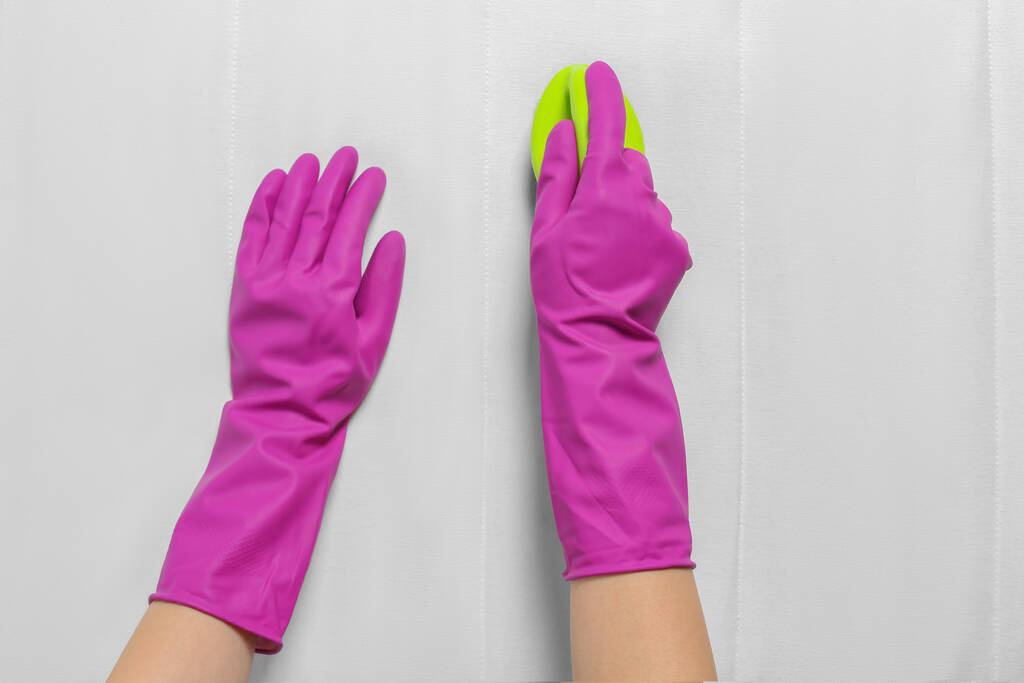 Жінка в фіолетових рукавичках чистить білий матрац пензлем, вид зверху
 - Фото, зображення