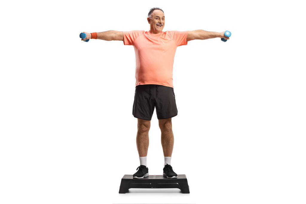 Ritratto completo di un uomo maturo che esercita il passo aerobico e tiene i pesi isolati su sfondo bianco - Foto, immagini