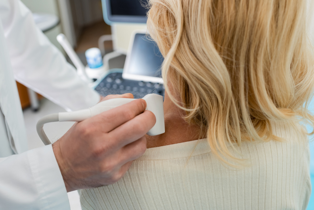 обрезанный взгляд врача на лимфатическую систему блондинки с ультразвуком - Фото, изображение
