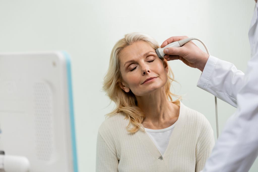 blondi nainen suljetut silmät lähellä lääkäri tekee pään ultraääni - Valokuva, kuva