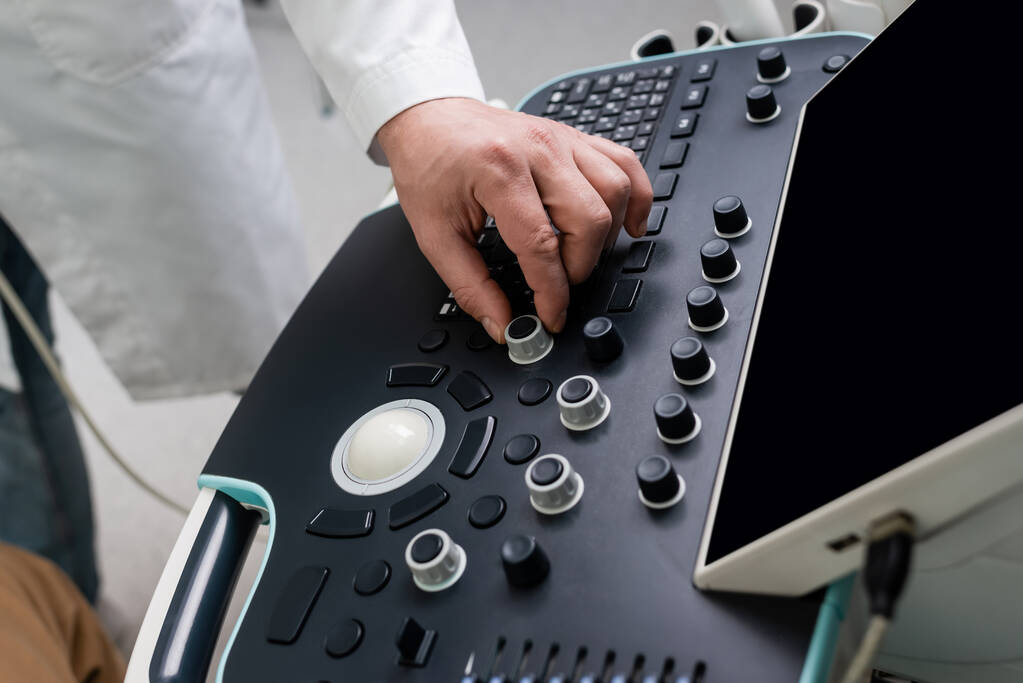 gedeeltelijk zicht op arts werken met moderne echografie machine in kliniek - Foto, afbeelding