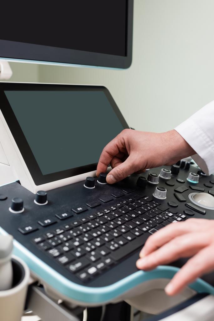 vista parziale del medico che regola la moderna macchina ad ultrasuoni in clinica - Foto, immagini