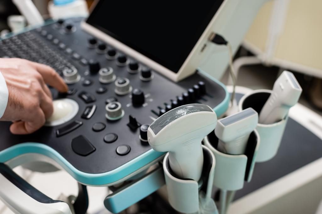 vista parcial del médico utilizando el panel de control de la máquina de ultrasonido en el hospital - Foto, imagen