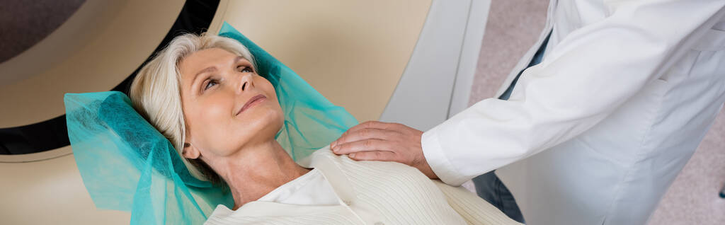 radiologista tocando ombro de mulher de meia-idade positiva antes da tomografia computadorizada na clínica, banner - Foto, Imagem