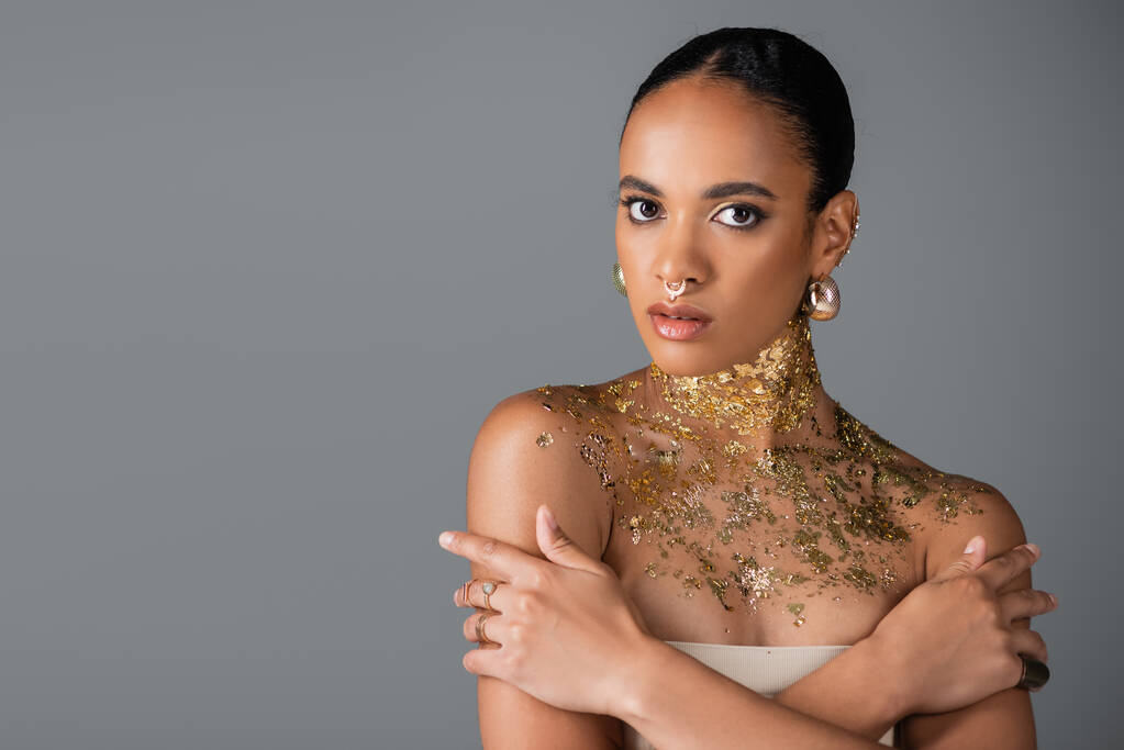 Hübsches und stylisches afrikanisch-amerikanisches Modell mit goldener Folie am Hals isoliert auf grau  - Foto, Bild