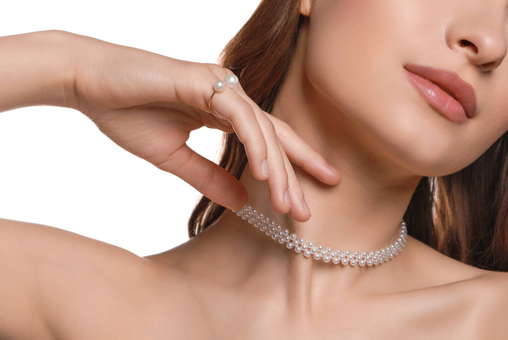 Jeune femme portant des bijoux de perles élégantes sur fond blanc, gros plan - Photo, image
