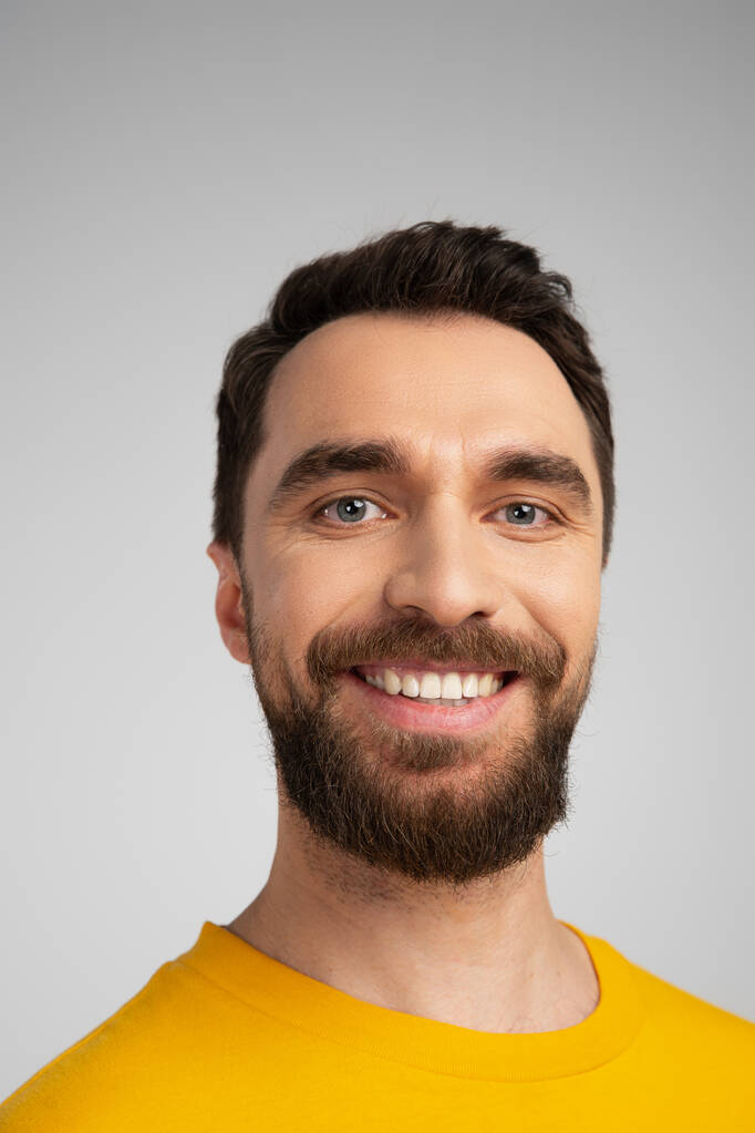 portré boldog szakállas férfi mosolyog kamera elszigetelt szürke - Fotó, kép