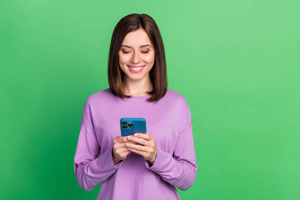Foto de mujer influencer positiva usando gadget leer reposts compartir aislado en fondo de color verde. - Foto, imagen