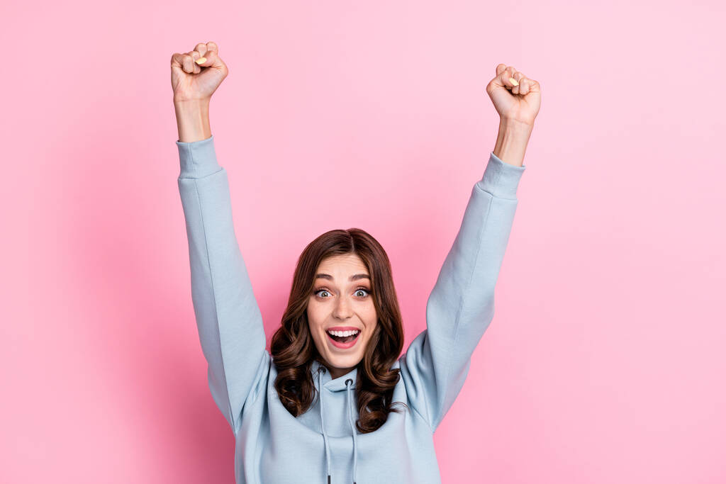 Photo of satisfied impressed girl raise hands fists success shout yes isolated on pink color background. - Photo, Image