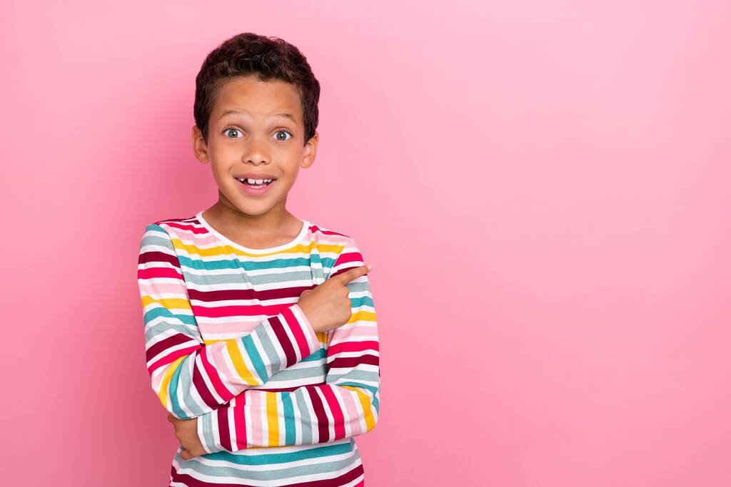 Foto van zoete charmante positieve jongen dragen gestreepte lange mouw onder de indruk aangegeven op lege ruimte geïsoleerd op roze kleur achtergrond. - Foto, afbeelding