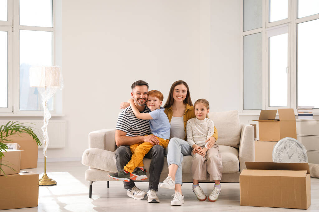 Boldog család ül a kanapén az új lakásban. Költözés napja - Fotó, kép