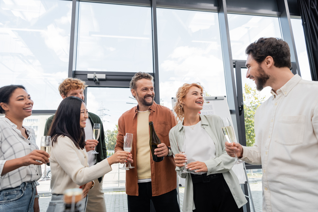 boldog multikulturális üzletemberek pezsgős poharakkal beszél a vállalati party alatt - Fotó, kép