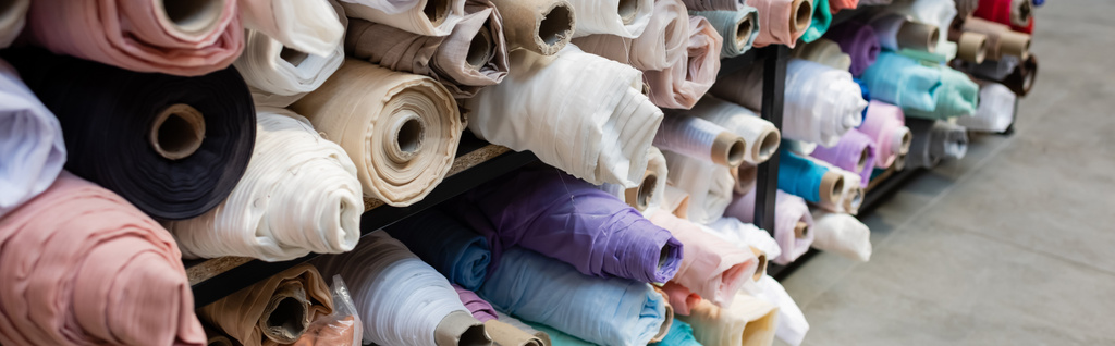 assortimento di diversi rotoli di tessuto su scaffali in negozio tessile, banner - Foto, immagini