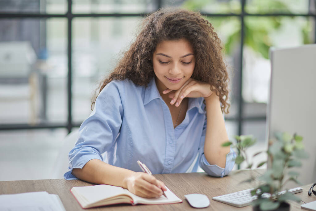 Mujer de negocios sosteniendo bolígrafos y papeles tomando notas en documentos sobre la mesa - Foto, Imagen