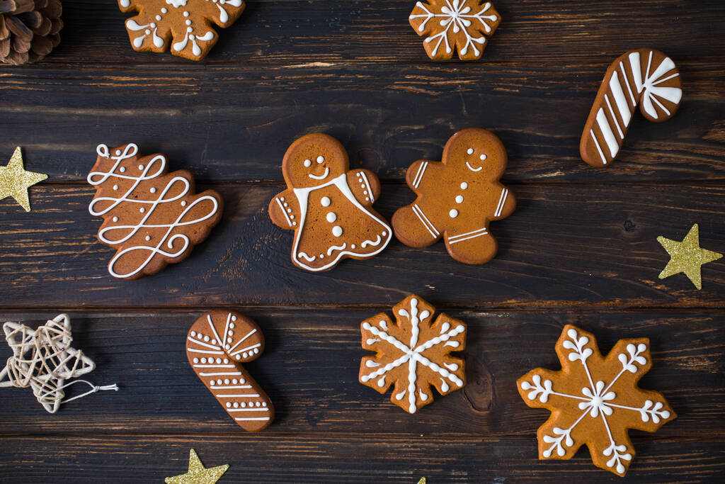 木製のテーブルの上に砂糖の装飾釉薬と様々な形状のクリスマスクッキー,装飾とフラットレイアウト - 写真・画像