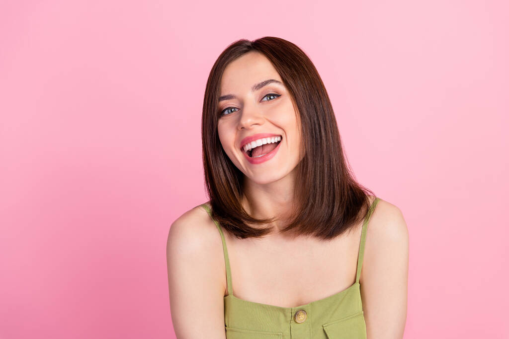 Foto von fröhlichen positiven attraktiven Mädchen mit Bob-Frisur tragen khaki top lächelnd Blick auf Kamera isoliert auf rosa Hintergrund. - Foto, Bild