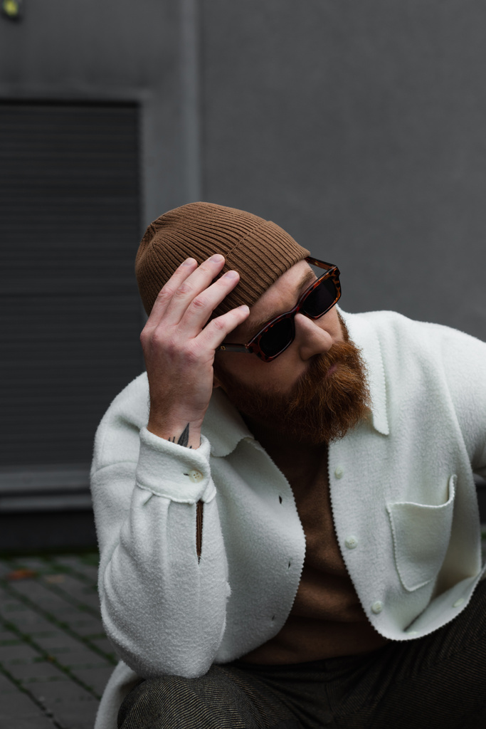 man met baard in stijlvolle zonnebril en witte hemd jas verstelbare muts - Foto, afbeelding