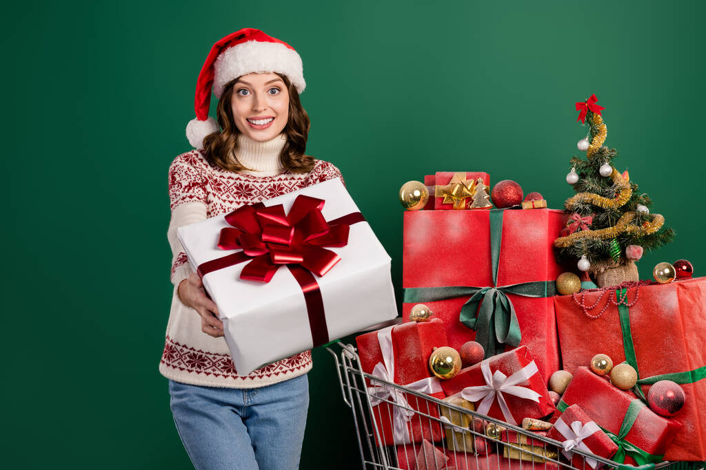 Portrait of pretty friendly lady hands hold give you festive giftbox isolated on green color background. - Photo, Image
