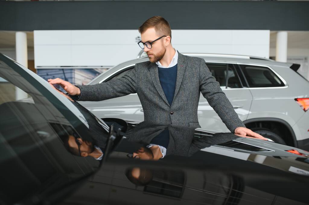 Man minded klient mężczyzna kupujący klient w garniturze wybrać auto, aby przejść na bok chcesz kupić nowy samochód w salonie samochodowym - Zdjęcie, obraz