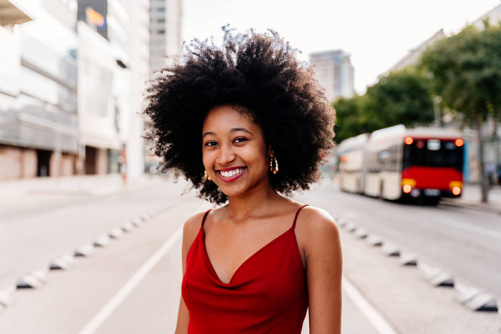 Hermosa joven feliz mujer africana con afro peinado rizado paseando por la ciudad - Alegre estudiante negro caminando por las calles - Foto, Imagen