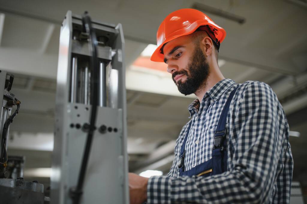 Portrait of Professional Heavy Industry Engineer, Worker Wears Safety Uniform, Hard Hat Smiling На фоні незосередженої великої промислової фабрики - Фото, зображення