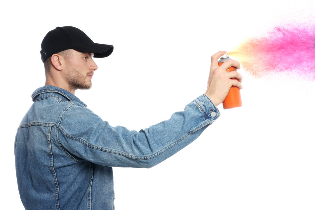 Handsome man spraying paint against white background - Photo, Image