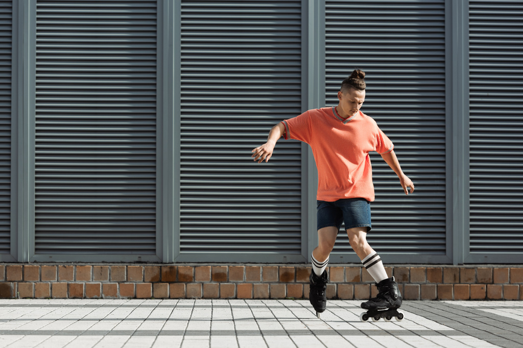 Görkorcsolyázó térdzokniban és rövidnadrágban korcsolyázás a városi utcán  - Fotó, kép