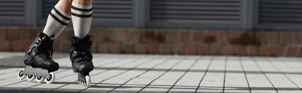 Обрезанный вид человека в коленных носках и роликовых коньках на открытом воздухе, баннер  - Фото, изображение