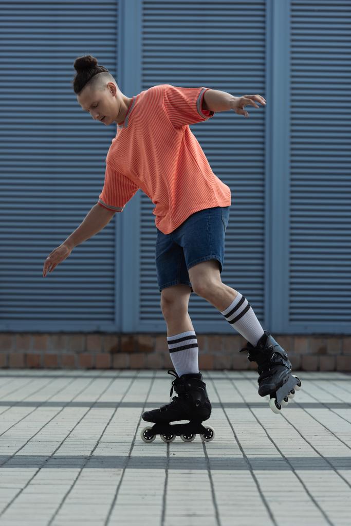 Young man in casual clothes riding roller blades outdoors  - Photo, Image