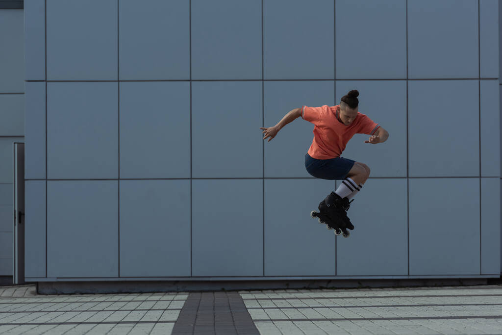 Νεαρός με casual ρούχα και ρολά πηδάει έξω  - Φωτογραφία, εικόνα