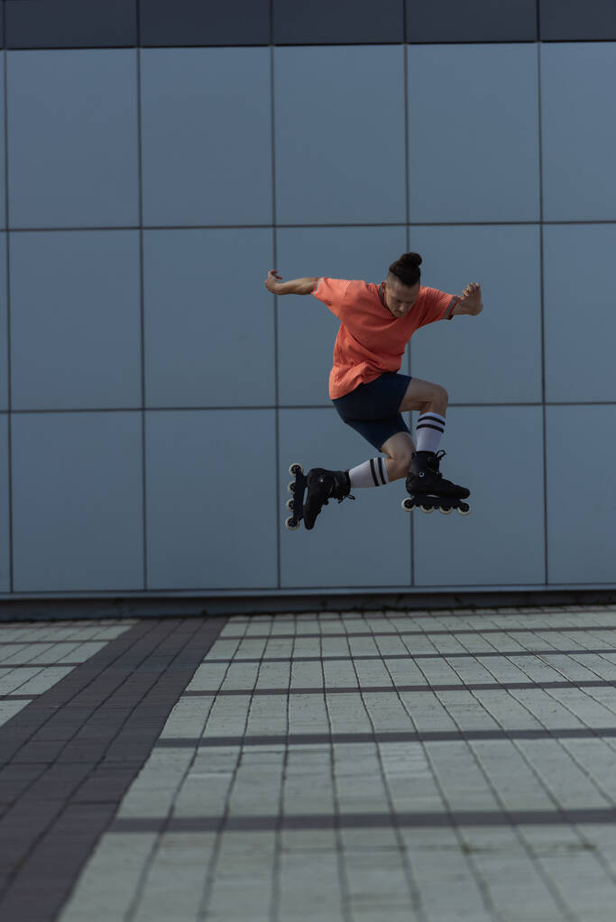 昼間は都会の通りをジャンプしながら、ローラートレーニングの男  - 写真・画像