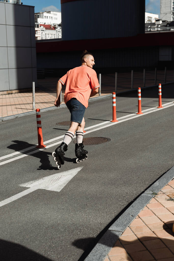 Oldalnézet az ember görkorcsolya korcsolyázás az úton a városi utcán  - Fotó, kép