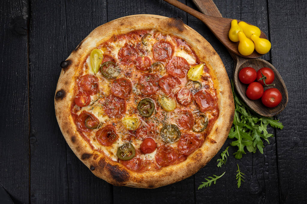 sabrosa pizza con queso y verduras en una mesa oscura de madera - Foto, imagen