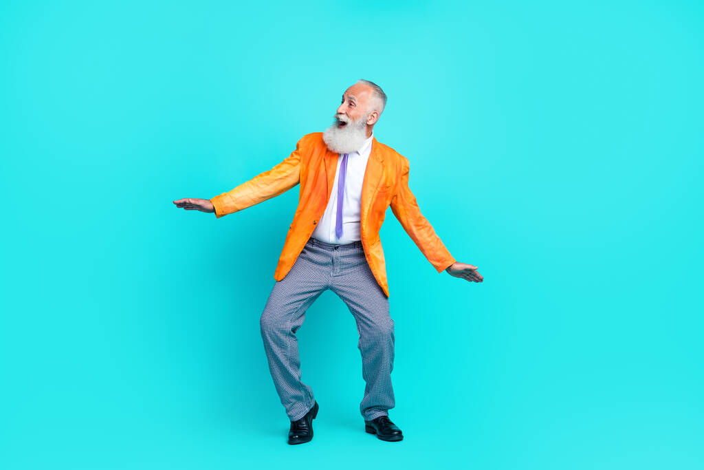 Foto de cuerpo entero de pensionista bastante sorprendido desgaste chaqueta naranja neón baile espacio vacío aislado color verde azulado fondo. - Foto, Imagen