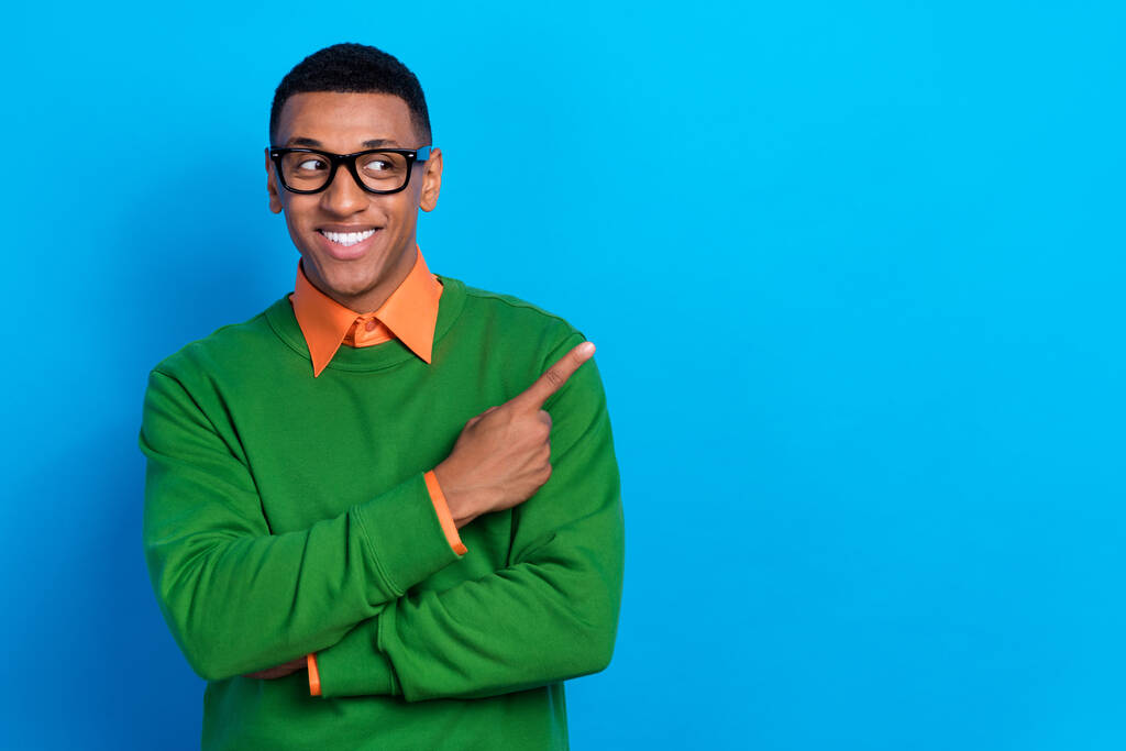 Φωτογραφία του θετικού χαρούμενου άνδρα ντυμένο πορτοκαλί πουκάμισο κάτω από πράσινο φούτερ σκηνοθεσία ματιά κενό χώρο που απομονώνονται σε μπλε φόντο χρώμα. - Φωτογραφία, εικόνα