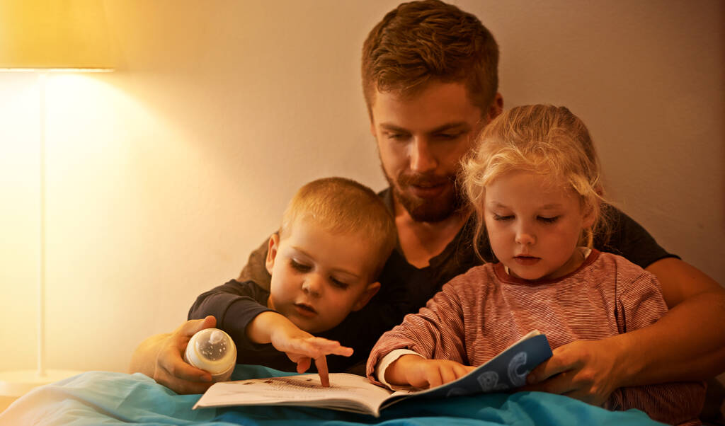 C'era una volta... un padre che leggeva una favola della buonanotte ai suoi figli. - Foto, immagini